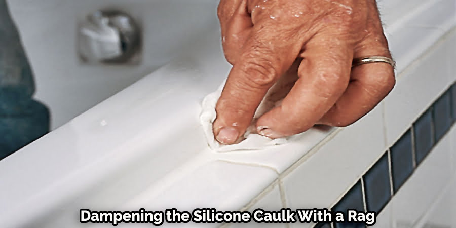 Dampening the Silicone Caulk With a Rag